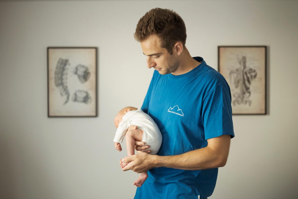 Therapist with an infant in the practice — pediatric osteopathy at Recovery Base Munich